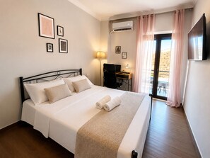 Ein Hotelzimmer mit Bett, Schreibtisch, Stuhl und Fernseher.