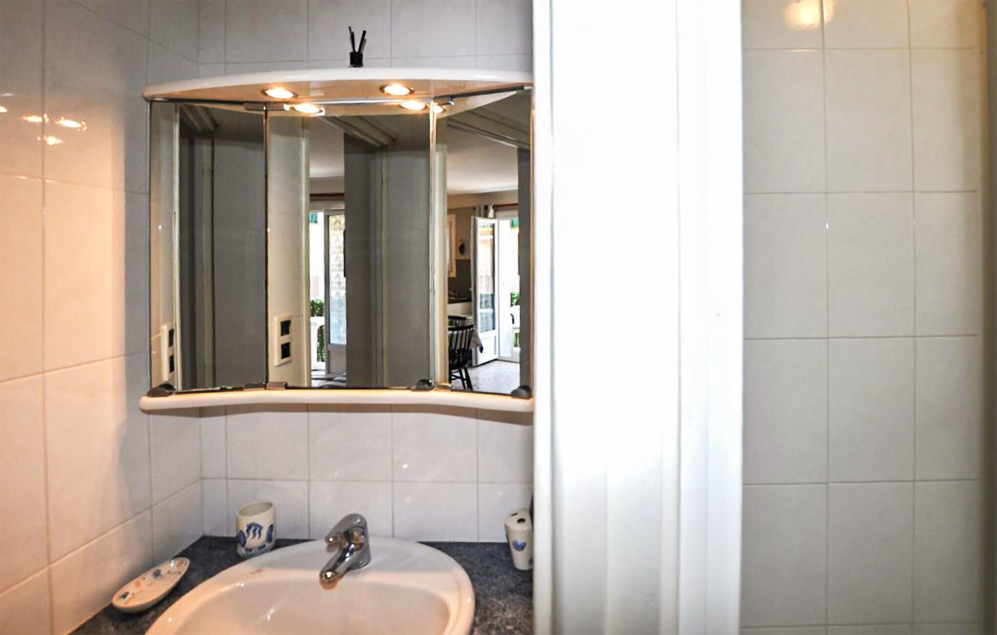 A bathroom with a white sink, a mirror, and a toilet.