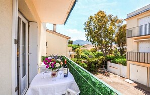 A balcony with a table set for dining, surrounded by greenery and a view of the neighborhood. - Stunning apartment in Argelès-Sur-Mer Plage (Argelès-Sur-Mer Plage)