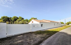 A long, white building with a tiled roof, a gated entrance, and a paved driveway. - Amazing home in Saint-Gervais (Saint-Gervais)
