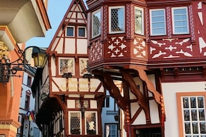 Ein traditionelles Fachwerkhäuschen mit Balkon und einem Schild, auf dem 'Wemsteine Speicherschl' steht.