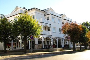 A two-story building with a balcony, arched windows, and a covered front porch. - No. 08 "Villa Laetitia" in Binz (Ostseebad Binz)