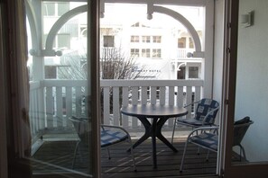 A balcony with a table and chairs, a white fence, and a building in the background. - No. 08 "Villa Laetitia" in Binz (Ostseebad Binz)