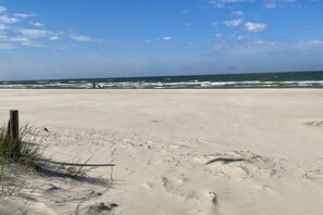 A sandy beach with footprints and a wooden post. - Holiday home Lake & Countryside (Zirchow)
