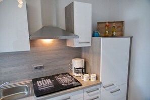 Eine Küchenzeile mit integrierter Kaffeemaschine, einer Kaffeestation und einem Schild mit der Frühstückskarte.