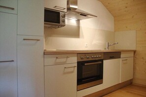 Eine kleine Küche mit Mikrowelle, Backofen und Spüle.