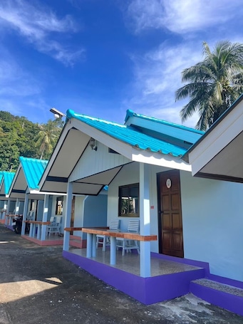 A row of single-story buildings with a blue roof, each with a porch and a door marked 'B2'.