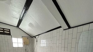A small, tiled bathroom with a toilet, a sink, and a shower. - Kerdmanee Resort (Ko Chang)