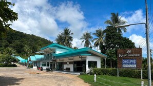 A resort with a modern building, a signboard, and a paved entrance. - Kerdmanee Resort (Ko Chang)