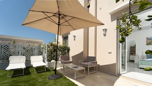 A patio with outdoor furniture, a table, and a large umbrella. - Estate4home - Capri Darly Apartment (Anacapri)