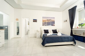 Een moderne slaapkamer met een groot bed, een nachtkastje, een dressoir en een raam met gordijnen.