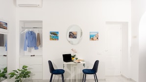 A modern room with a white desk, two chairs, a laptop, a potted plant, and a mirror on the wall. - Estate4home - Capri Darly Apartment (Anacapri)