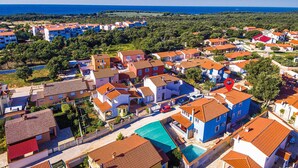 Una zona residenziale sulla costa, con case, una piscina e vista sul mare.