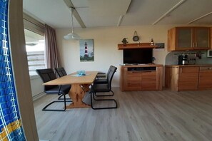 Eine kleine Küche mit Esstisch, St ühlen und einem Fernseher.