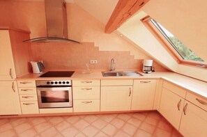 Eine moderne Küche mit Backofen, Spüle und einem Fenster mit Blick auf Grünflächen.