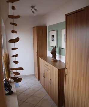 Ein Flur mit Holzausstattung, einem Deckenventilator und einer Wandskulptur.