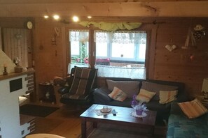 Ein gemütliches Wohnzimmer mit einer Couch, einem Sessel und einem Couchtisch.