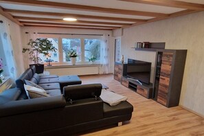 Een moderne woonkamer met een modulaire bank, een flatscreen televisie en een open haard.