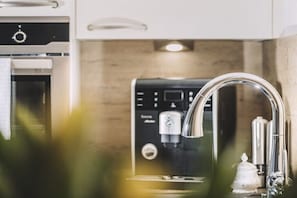 Eine Küche mit einer Kaffeemaschine, einem Edelstahlarmaturen und einem Schrank.