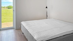 A bedroom with a bed, a window, and a floor lamp. - Awesome home in Spøttrup with WiFi (Spøttrup)