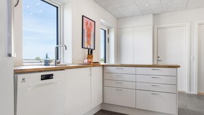 A modern kitchen with white cabinetry, a dishwasher, a countertop with a sink, and a window providing natural light. - Awesome home in Spøttrup with WiFi (Spøttrup)