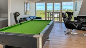 A pool table in a room with a view of the outdoors, a seating area with a sofa and chairs, and a door leading outside. - Awesome home in Spøttrup with WiFi (Spøttrup)