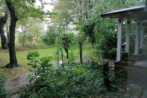 A garden with a gazebo, trees, and a pathway. - Holiday farmhouse with 2 bedrooms (Langenhorn)