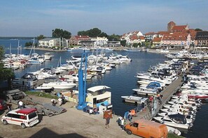 A marina with boats docked, a blue crane, and buildings in the background. - Holiday apartment in Waren with swimming pool (Waren)