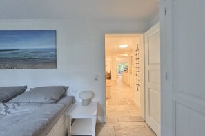 Ein Schlafzimmer mit Bett, Nachttisch und einem Bild von einer Strandlandschaft.