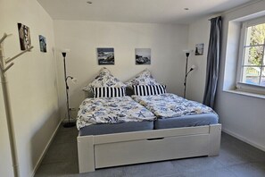 Ein Schlafzimmer mit einem Bett, zwei Wandlampen und zwei gerahmten Bildern.