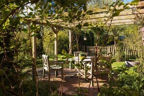 Eine Gartenpatio mit Holzmöbeln und einer Pergola.