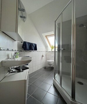 A modern bathroom with a shower, a sink, and a toilet. - Holiday apartment Lillehus (Leipzig)