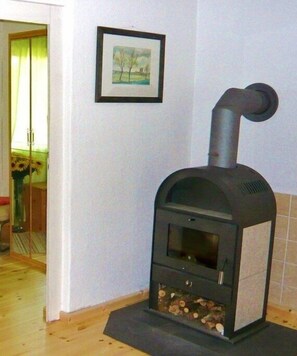 Ein Kamin mit Schornstein, ein gerahmtes Bild an der Wand und eine Tür zu einem anderen Raum.
