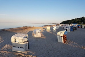 Strandhäuser mit den Nummern 150, 27, 99 und 15, mit Blick auf das Meer.