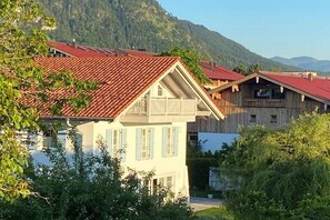 Ein traditionelles Chalet mit geneigtem Dach, Holzfassade und Balkon.