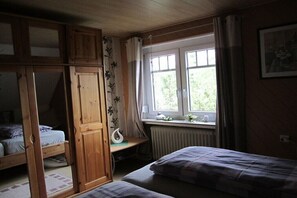 A bedroom with a bunk bed, a desk, and a window with curtains. - "Röben Vegetable Farm" (Zetel)