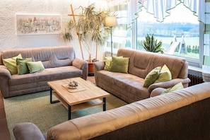 Ein Wohnzimmer mit zwei Sofas, einem Couchtisch und einem großen Fenster mit Blick.