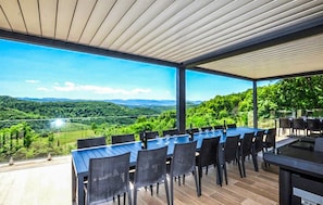 Ein Essbereich im Freien mit Tisch und Stühlen mit Blick auf eine malerische Landschaft.