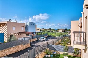 A residential area with modern buildings, a car parked on a driveway, and a clear blue sky.
