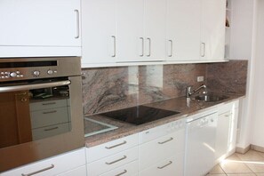 A kitchen with white cabinets, a Bosch dishwasher, a stainless steel oven, and a granite countertop. - Holiday apartment in Krün with Wi-Fi (Krün)