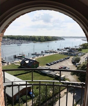 Ein Yachthafen mit vertäuten Booten, ein Parkplatz und ein Gebäude mit Schrägdach.