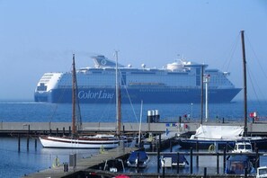A large cruise ship docked at a marina with smaller boats nearby. - Holiday apartment in Laboe with swimming pool (Laboe)