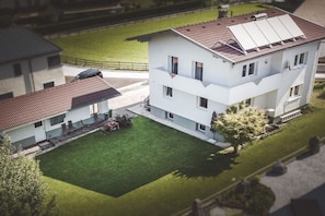 Ein zweistöckiges Gebäude mit flachem Dach, Solaranlagen und einem gepflegten Rasen.