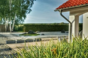Ein angelegter Garten mit einem Weg, der zu einem Gebäude mit roten Ziegeln führt.