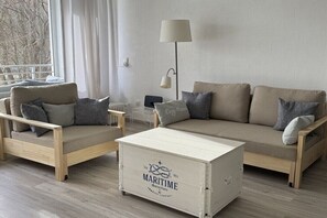 Ein modernes Wohnzimmer mit zwei Sofas, einem Couchtisch und einer Lampe.