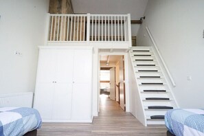 Ein Zimmer mit Etagenbett, Schrank und Treppe.