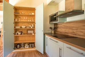 Eine Küche mit Holzregalen, einer Mikrowelle und einem Herd.