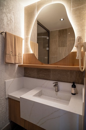 Uma casa de banho moderna com um espelho grande, uma pia e um secador de cabelo.