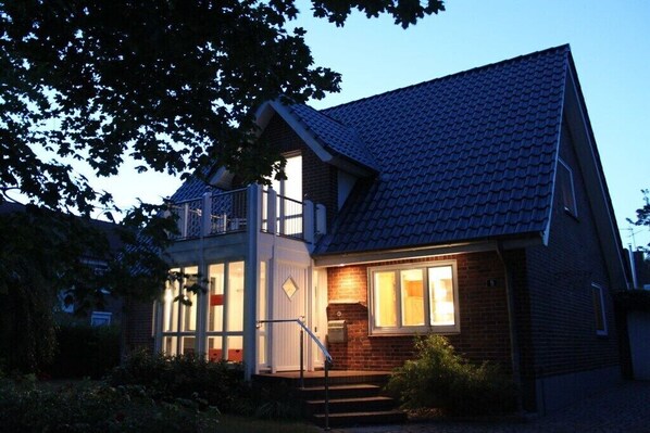 Ein zweistöckiges Haus mit Balkon, Eingangstür und Fenster.