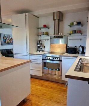 Eine kleine Küche mit eingebautem Ofen, einer Kaffeemaschine und einem Toaster.
